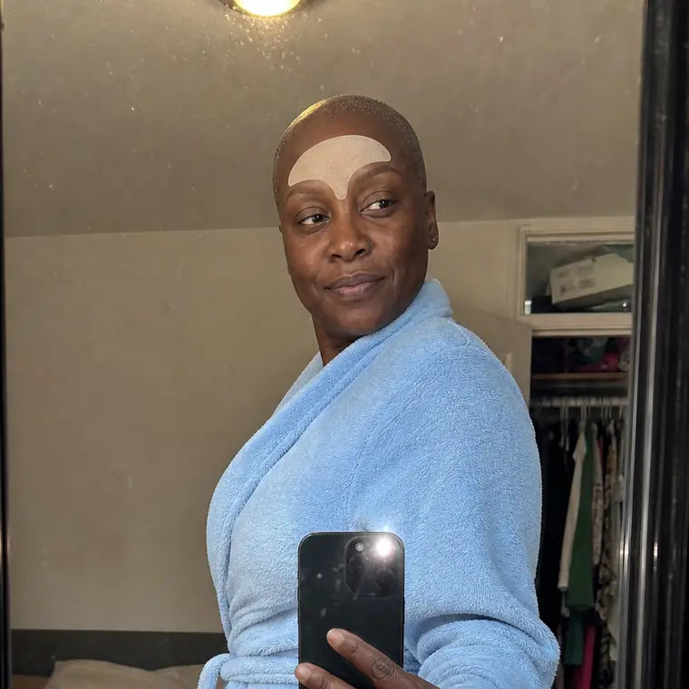 Selam, taking a mirror selfie in a robe